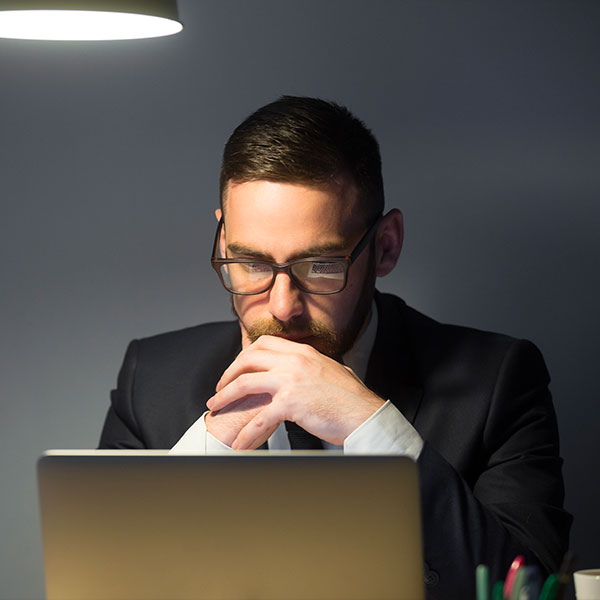 un homme concentré devant son ordinateur